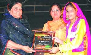 A student gets a prize from education minister Upinderjit Kaur.