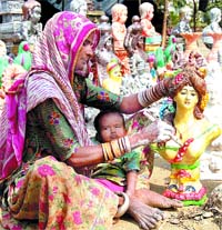 A roadside artisan touches up a sculpture in Jalandhar. Photo: Suryakant