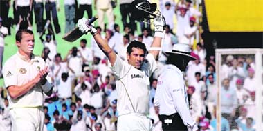 Sachin Tendulkar celebrates after he became the highest run-scorer on the first day of the second Test match against Australia in Mohali
