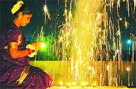 A woman performs puja amidst fireworks on the eve of Divali in Jalandhar