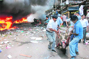 People carry the body of a woman from the blast site at the Ganeshguri area in Guwahati on Thursday.