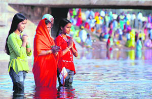 Devotees pray at the Sidhwan Canal bridge on the occasion of Chhat Puja in Ludhiana on Tuesday.
