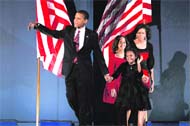 US President-elect Barack Obama walks on stage with his wife Michelle and daughters Malia  and Sasha during an election night gathering in Grant Park