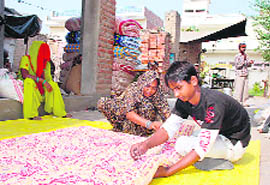 Anticipating brisk sales in the days to come, a mother-son duo stitches a quilt in Hisar.