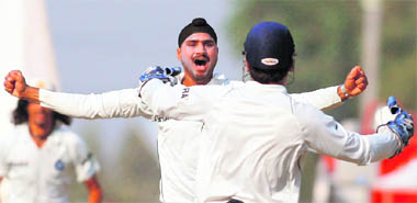 Harbhajan Singh celebrates with teammate Mahendra Singh Dhoni