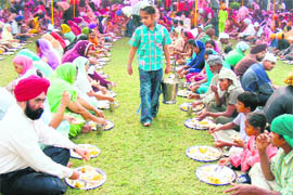 Devotees partaking langar at a gurdwara in Ludhiana on the occasion of Gurpurb on Thursday.