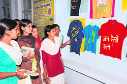 Students look at T-shirts with environment-related slogans at an exhibition in Hisar.