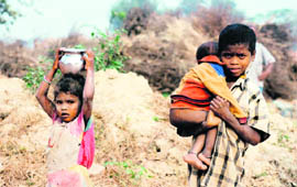 Children carry water at a brick-kiln near Barota village in Karnal.