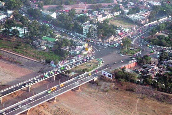 From on high : gazing down, Jammu city looks resplendent and at peace with itself as traffic crawls over bridges and on roads on a sunny day.