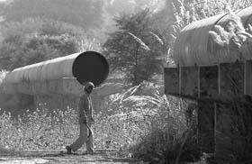 A villager walks past the incomplete pipeline of the Dholpur-Bharatpur water transmission project, which was to supply drinking water to two districts in Rajasthan