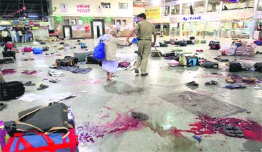 A policeman walks with an elderly man after shooting by terrorists at the Central Shivaji Terminus in Mumbai on Wednesday night.