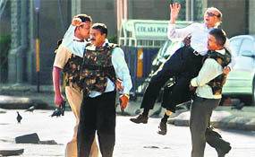Policemen escort a holed-up guest from Taj hotel