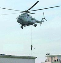 A National Security Guards commando rappels from a helicopter near Nariman House from where hostages were freed on Friday night.