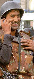 An NSG commando talks on the phone after terrorists were flushed out of the Taj hotel.