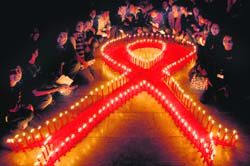 Members of the Community Care Centre, for people living with HIV AIDS, form a ribbon with red candles to mark World AIDS Day at Sukhna Lake in Chandigarh on Monday.