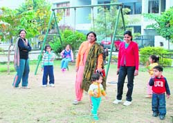 Children accompanied by their mothers play in a park in Sector 38-West, Chandigarh, on Monday.