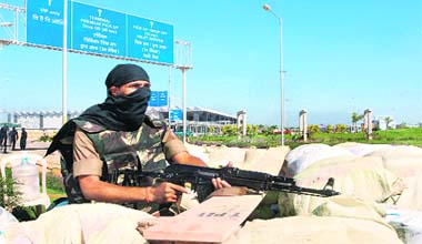 A commando from the Central Industrial Security Force stands guard outside the terminal building of Bangalore airport