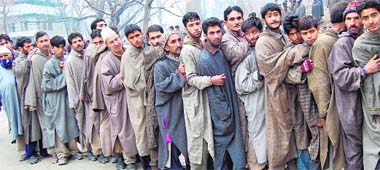 Voters wait their turn outside a polling station at Magam during the fourth-phase Assembly polls in Badgam district, 35 km from Srinagar