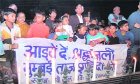 Local residents, including children, pay tributes to the victims of the Mumbai terror attacks