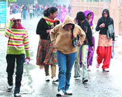 Students walk in the rain in Amritsar on Tuesday.