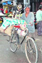 A man gives a ride to his pet on his bicycle near Kangra