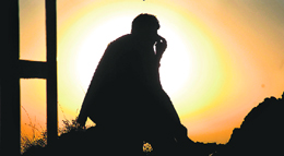 A man watches the sunset on the outskirts of Jammu.
