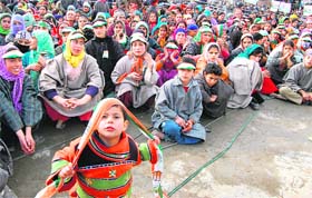 Kashmiri women wear Congress caps as they listen to Prime Minister Manmohan Singh at an election rally at Khandroo in Anantnag district, some 75 km from Srinagar