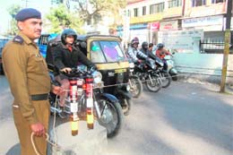 With no zebra crossing in place, a policeman uses a rope to regulate traffic near Kanak Chowk in Dehradun on Monday.