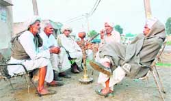 Elders of Rajpura village in Hisar district hold their daily meeting as one of them smokes a hookah despite a ban on smoking at public places