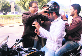 The Vice-Chancellor, R.C. Sobti, makes students aware about wearing helmet on the campus on Monday.