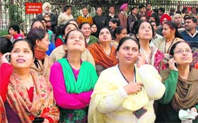 Anxious onlookers watch the rescue operation during a mock drill conducted at the Reserve Bank of India office in Sector 17, Chandigarh