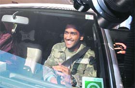 Mahendra Singh Dhoni sits in a car after his meeting with a senior police official in Ranchi