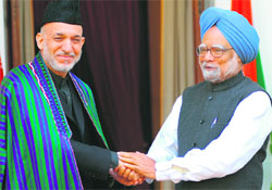 Prime Minister Manmohan Singh shakes hands with Afghan President Hamid Karzai prior to a meeting at Hyderabad House in New Delhi on Monday.