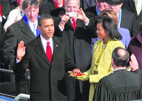 Barack Obama takes oath as the 44th President of the United States as his wife Michelle holds the Bible during