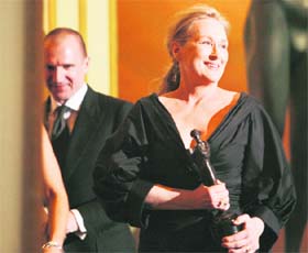Actor Meryl Streep walks off the stage after getting an award for the Outstanding Performance by a Female Actor in a Leading Role for Doubt as actor Ralph Fiennes (back) looks on