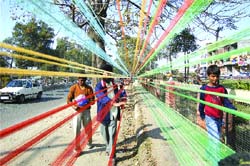 Sellers apply a colourful mixture on kite strings in Jalandhar.