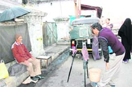 A man gets himself clicked by a photographer using the old box camera at Darshan Lal Chowk in Dehradun.