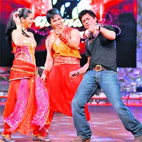 Bollywood actor Shah Rukh Khan (right) dances with winners Shaleen Bhanot (middle) and Daljeet Kaur (left) during the Grand Finale of Nach Baliye-4
