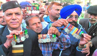 READY FOR ANOTHER BATTLE: Ex-servicemen, demanding the implementation of one rank, one pension, show their gallantry medals before returning them in protest to President Pratibha Patil at Jantar Mantar in New Delhi