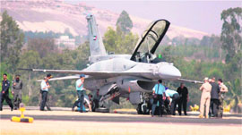 Technicians work on a F-16 aircrafts wheel which burst while take off during the last day of the Aero India-2009 at Yelshanka air base in Bangalore on Sunday.