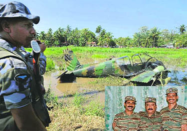A Sri Lankan soldier stands next to the wreckage of a Tamil Tiger light aircraft lying in a marsh in Katunayaka, near Colombo, on Saturday, a day after it was shot down by government forces just outside the islands only international airport.