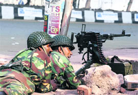 Army soldiers take their positions on a street near the headquarters of the paramilitary Bangladesh Rifles in Dhaka on Wednesday.