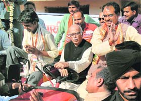 BJP leader LK Advani tries his hand at driving a tractor as Madhya Pradesh CM Shivraj Singh Chouhan looks on at a loan distribution ceremony in Gwalior