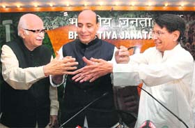 BJP leader LK Advani shakes hands with Rashtriya Lok Dal leader Ajit Singh, as BJP president Rajnath Singh looks on, during a press conference in New Delhi