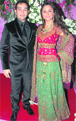Actor Amrita Arora and her groom Shakeel Ladak pose for a picture during their wedding reception