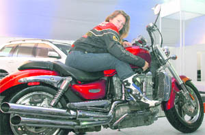 A firang beauty ups the sizzle quotient as she checks out this bike on display
