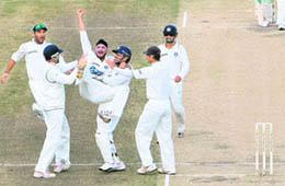 Harbhajan Singh is lifted by his teammates for the wicket of New Zealand captain Daniel Vettori during the fourth day of the first Test at Seddon Park in Hamilton on Saturday.