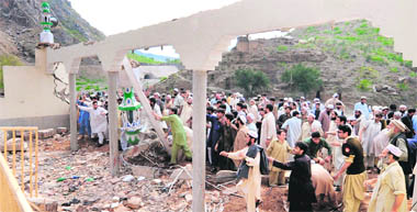 Pakistani tribesmen search for victims amidst the debris at the site of a sucide blast at a mosque in the town of Jamrud on Friday.