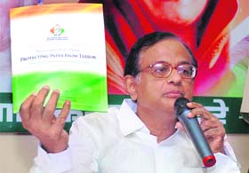 Home Minister P Chidambaram shows the Congress manifesto at a press conference in Mumbai