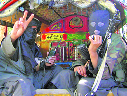 Pakistani Taliban fighters gesture towards the camera before leaving Buner, about 100 km from Islamabad, on Friday.